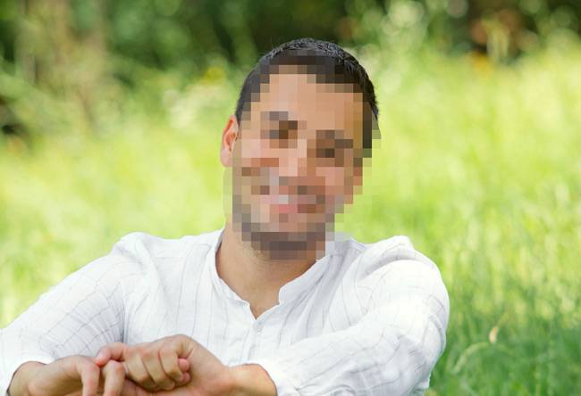 בחור יושב על הדשא עם פנים מטושטשות