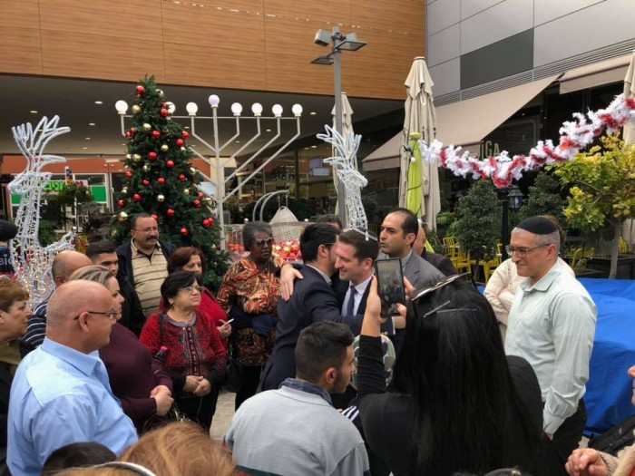 אלי נכט מארח משלחות מחו"ל ליד עץ האשוח בביג