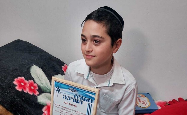 מיכאל סבג ותעודת ההערכה שקיבל מהמשטרה.